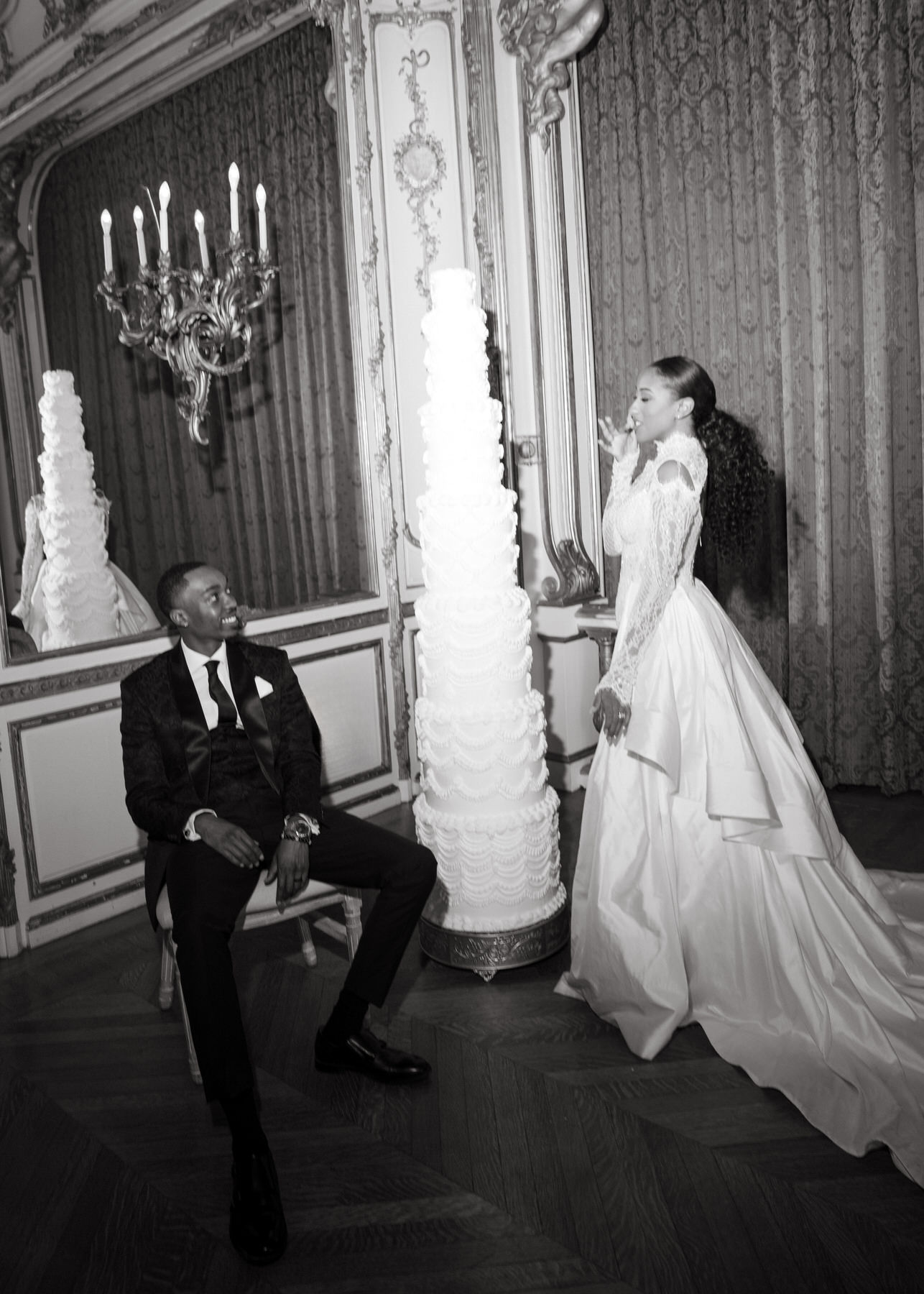 Bride and groom sharing a playful moment near the wedding cake during their elegant celebration at Ochre Court Newport.