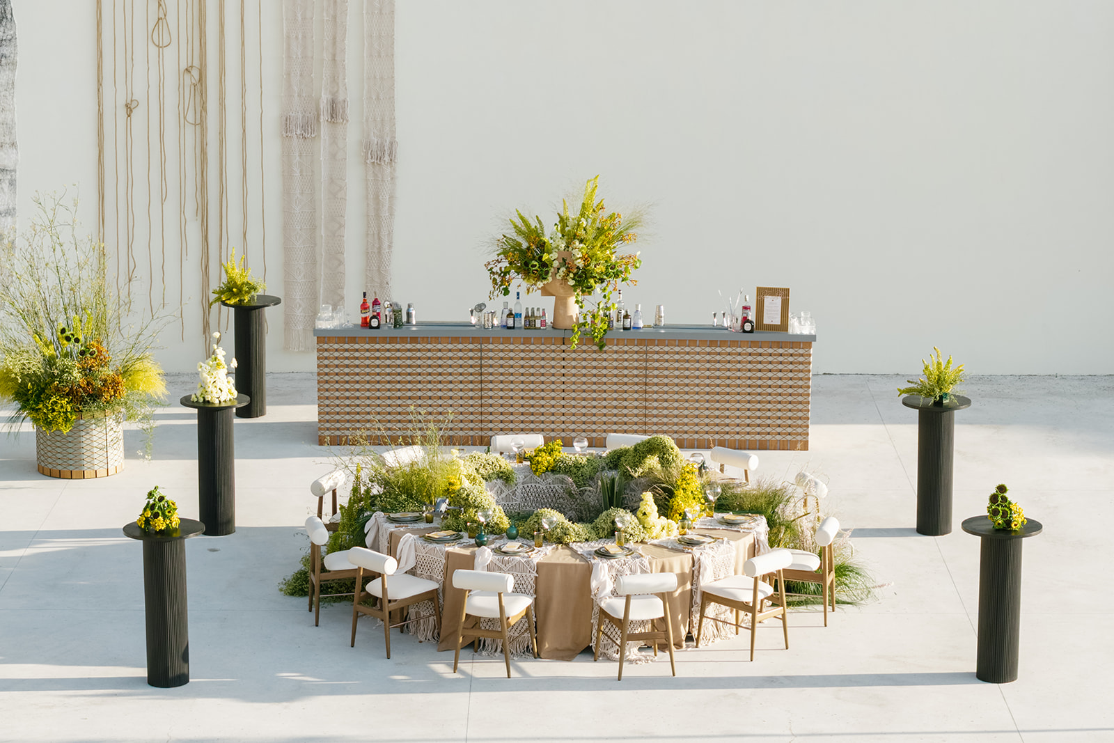 Circular reception table surrounded by yellow floral installations before a tiled bar at Cava Puglia.