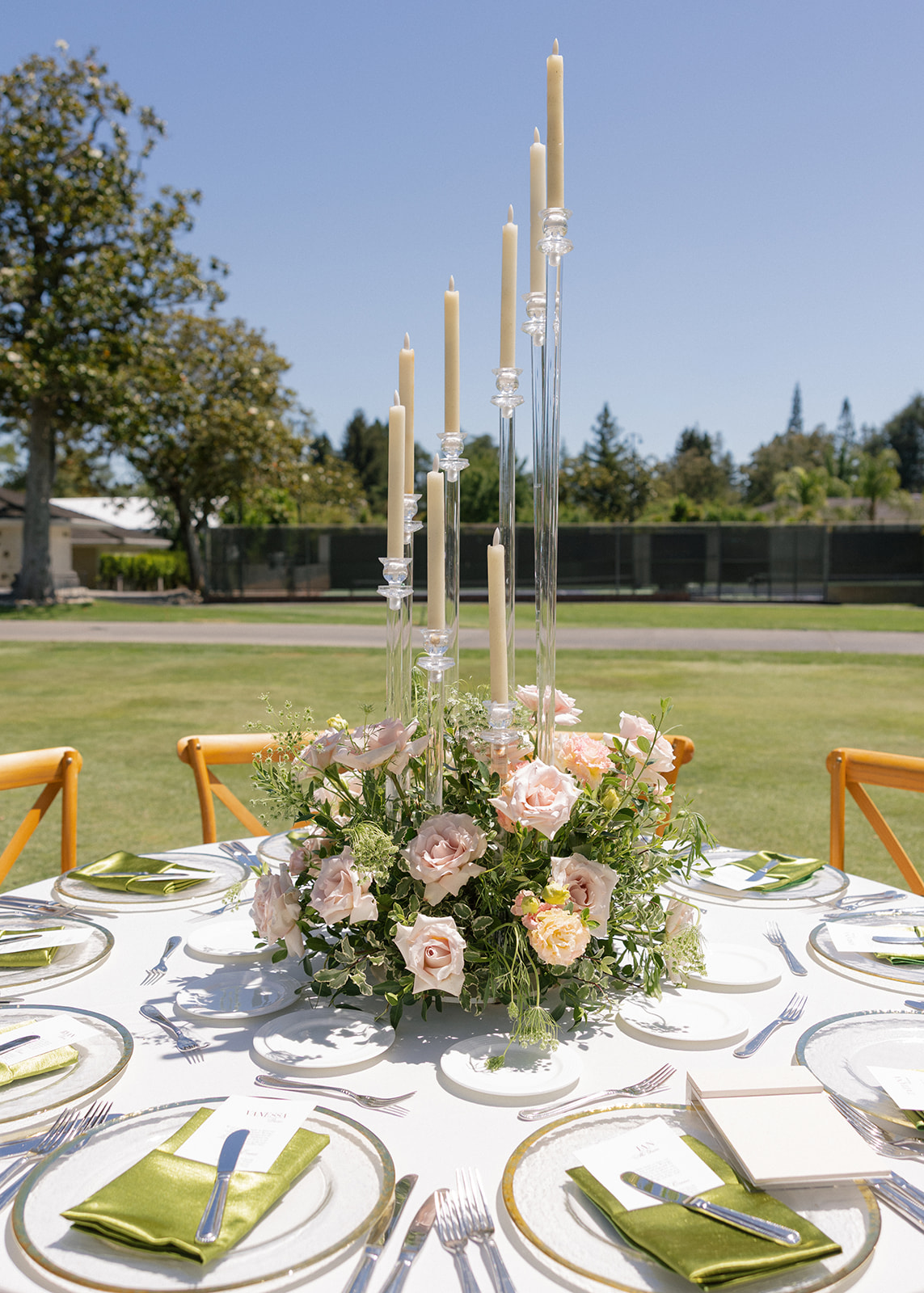 Pastel floral centerpiece, taper candles, and green napkins on a table at Silverado Resort in Napa.