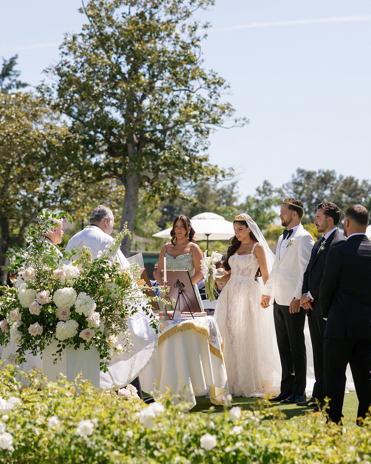 Bride and groom stand at a flower-lined outdoor altar during their ceremony at Silverado Resort in Napa.