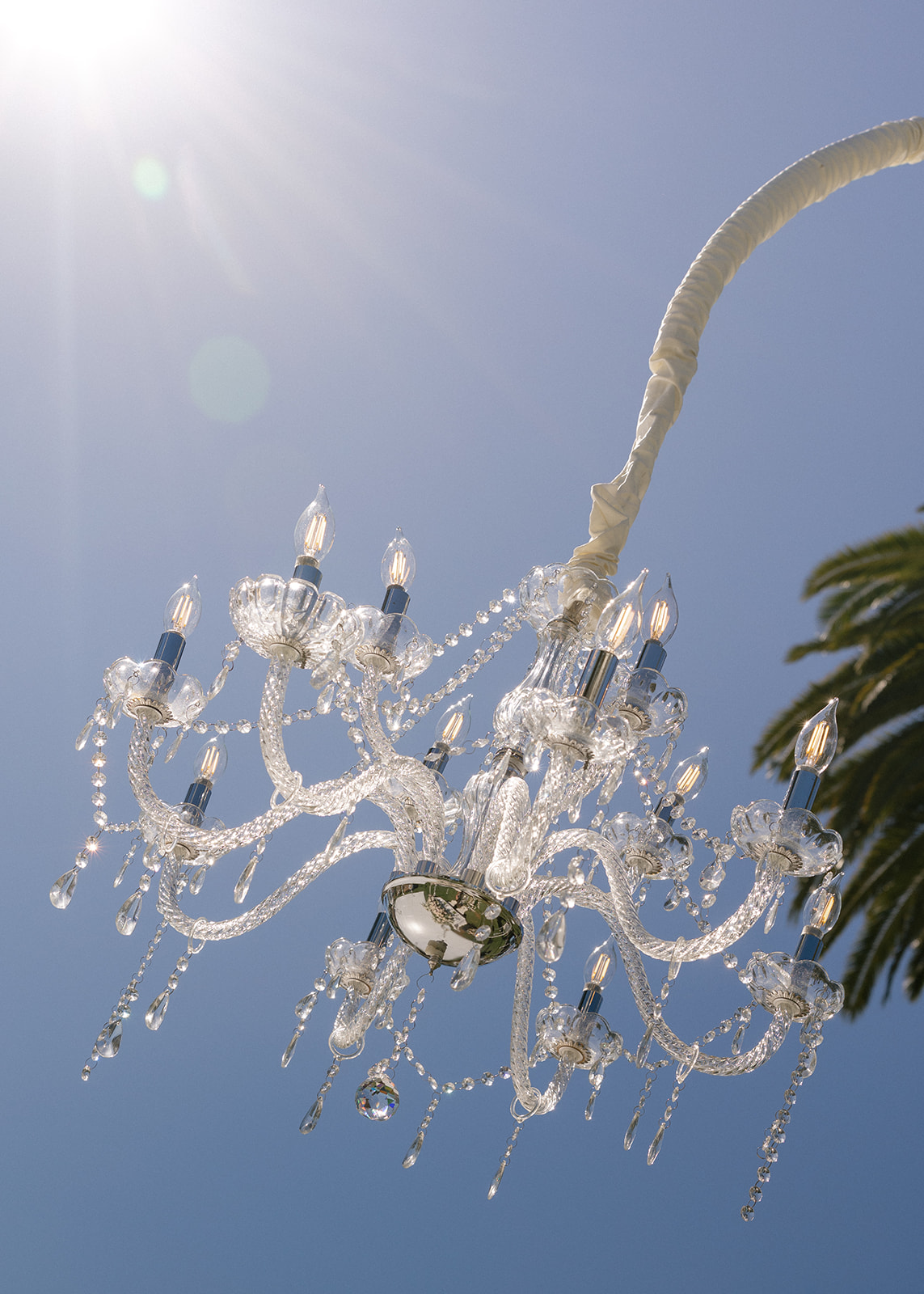 Crystal chandelier hangs outdoors against a blue sky at Silverado Resort in Napa.