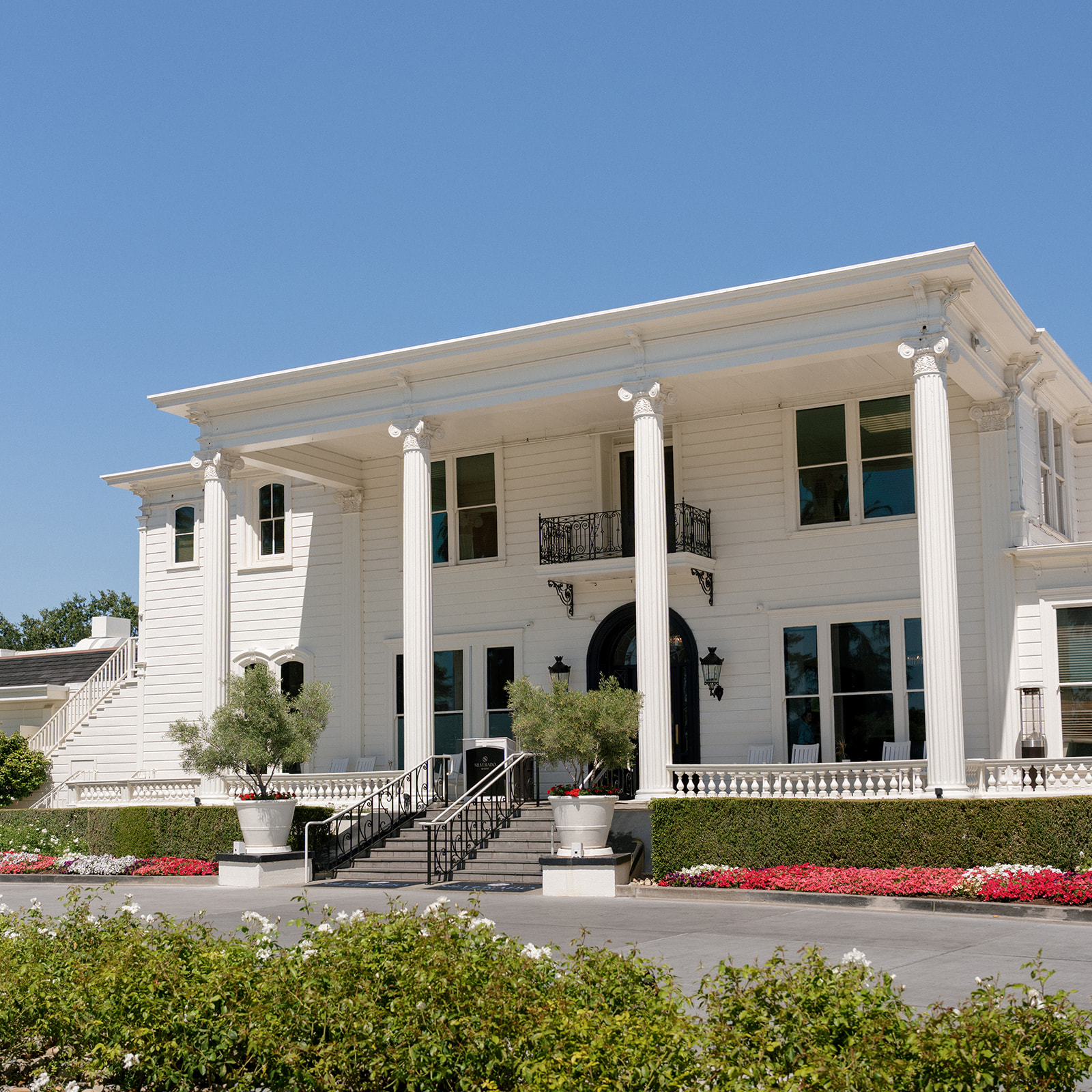 White mansion with tall columns and landscaped flower beds at Silverado Resort in Napa.