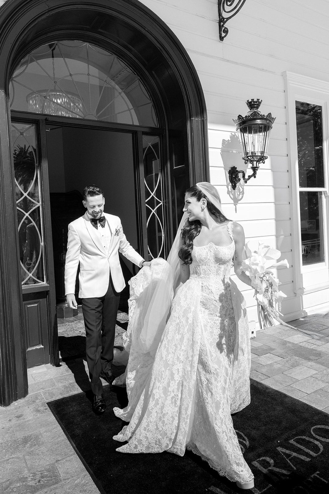 Bride and groom step through the arched mansion entrance at Silverado Resort in Napa.