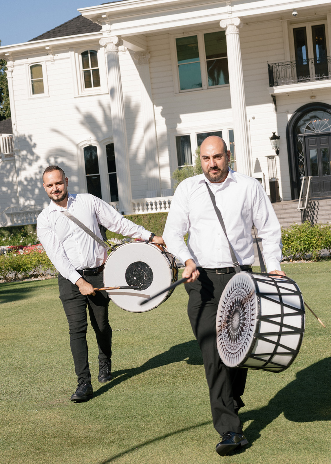 Two percussionists carry large drums across the lawn at Silverado Resort in Napa.