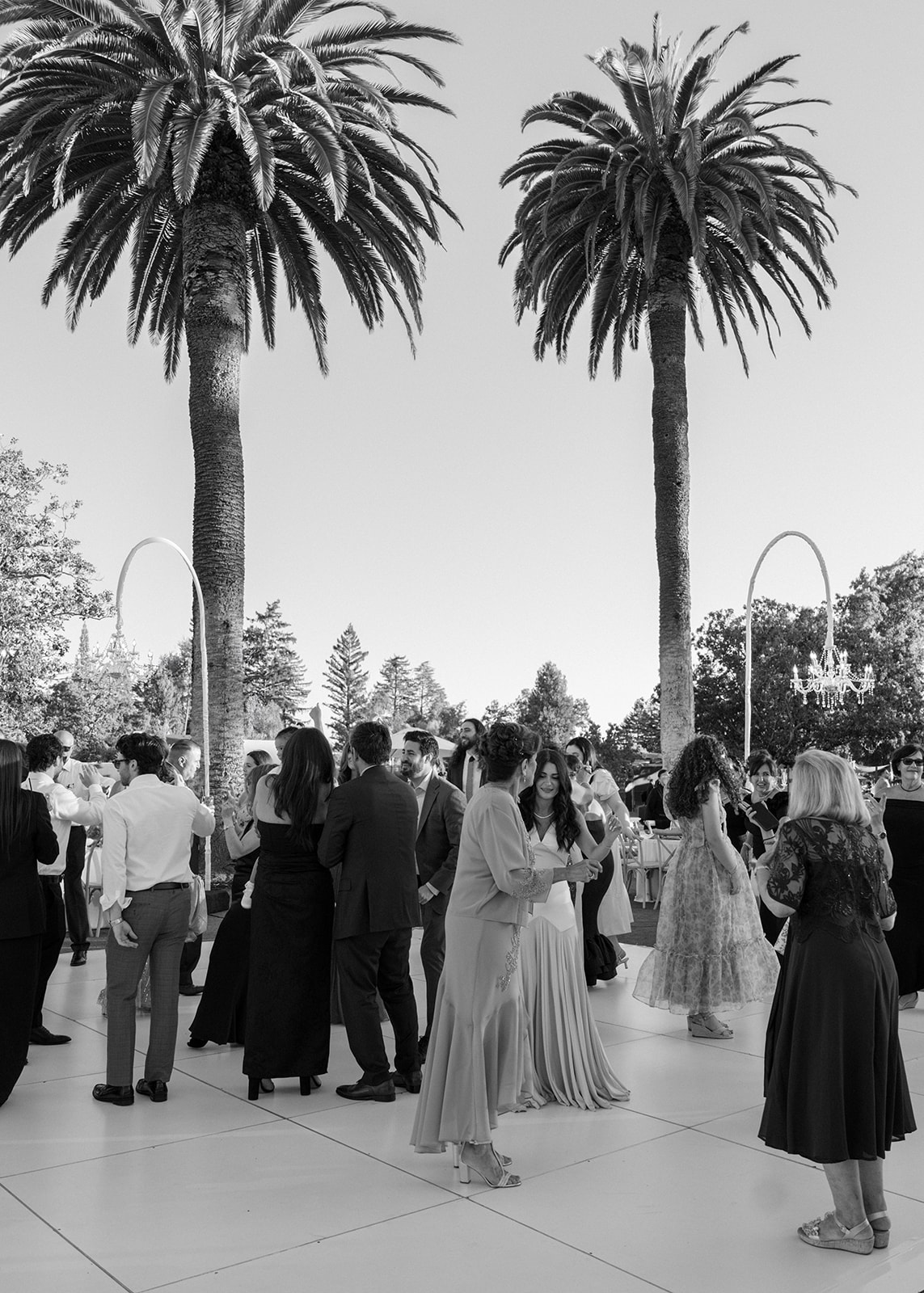 Guests dance on an outdoor reception floor between palm trees at Silverado Resort in Napa.